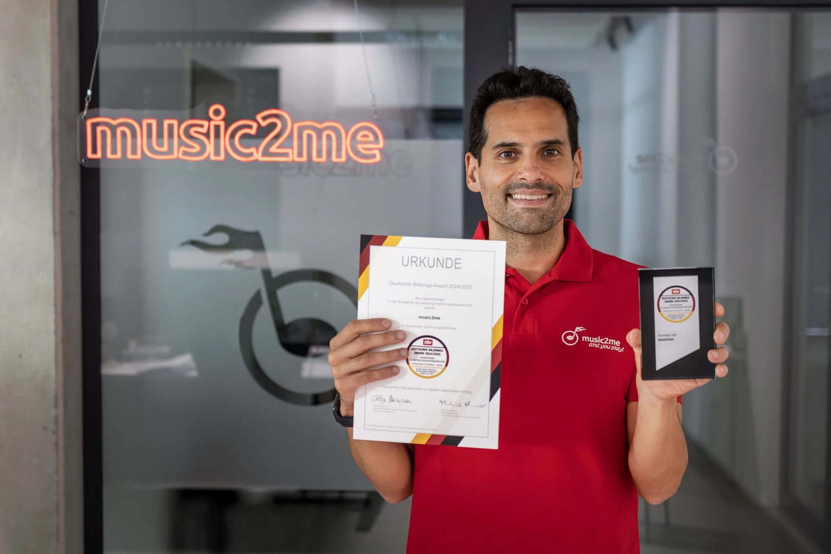 acine Khorchi hält Urkunde und Auszeichnung des NTV Bildungsawards.