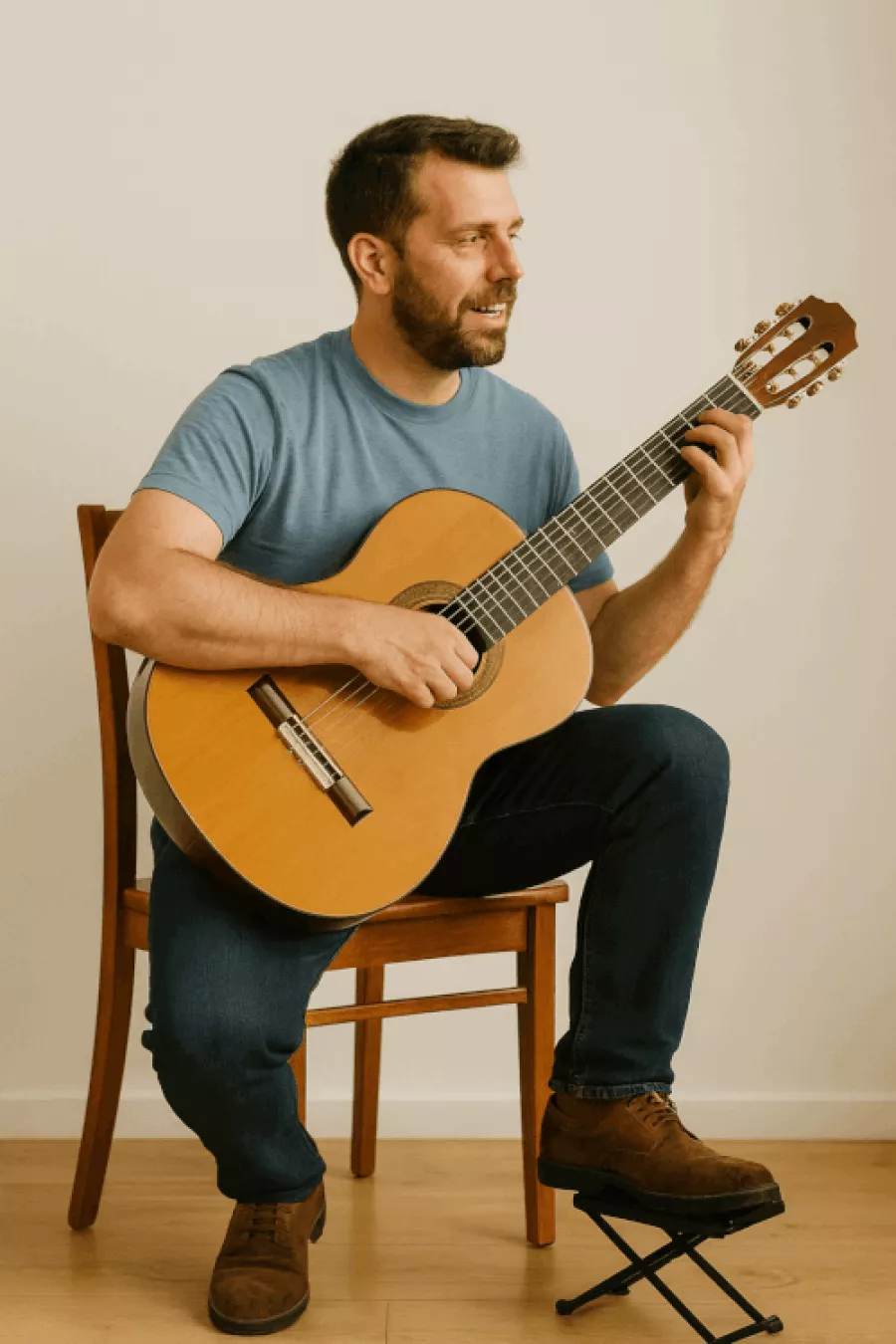 Mann in klassischer Sitzposition beim Gitarrespielen.