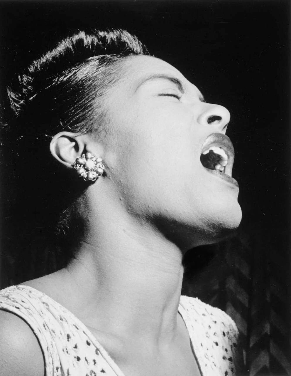 Schwarz-weiß-Aufnahme von Billie Holiday beim Singen.